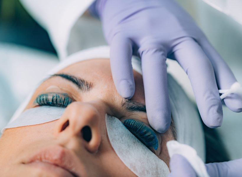 Cosmetologist Puts Black Paint on the Eyelashes During Lash Lifting Procedure. Laminating Eyelashes.