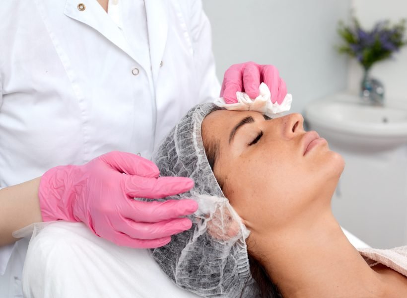 Woman having cleaning facial treatment in spa.